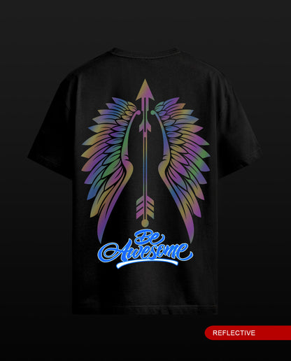 A black short-sleeve t-shirt shown from the back, featuring a large graphic of rainbow-colored wings and an arrow with the text 'Be Awesome' in blue. A red label in the bottom right corner reads 'REFLECTIVE'.