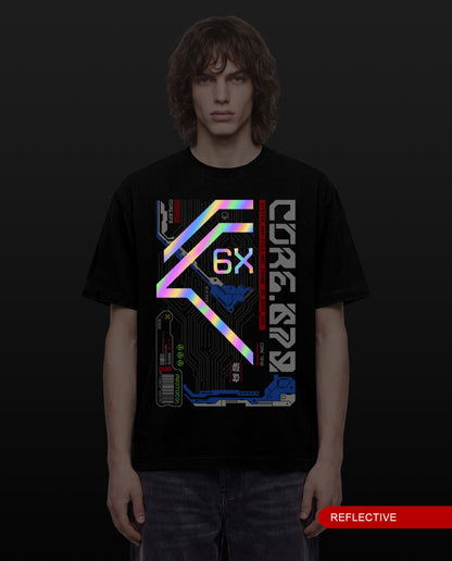 A man wearing a black short-sleeve t-shirt with a large futuristic reflective graphic on the front, featuring neon pink, blue, and green accents, set against a dark background.