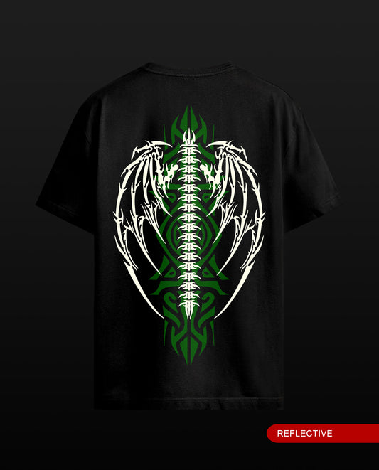 A black short-sleeve t-shirt shown from the back, featuring a large graphic of a white winged skeleton spine with green tribal-style patterns running down the center. The word 'REFLECTIVE' is printed in white on a red tab at the bottom right.